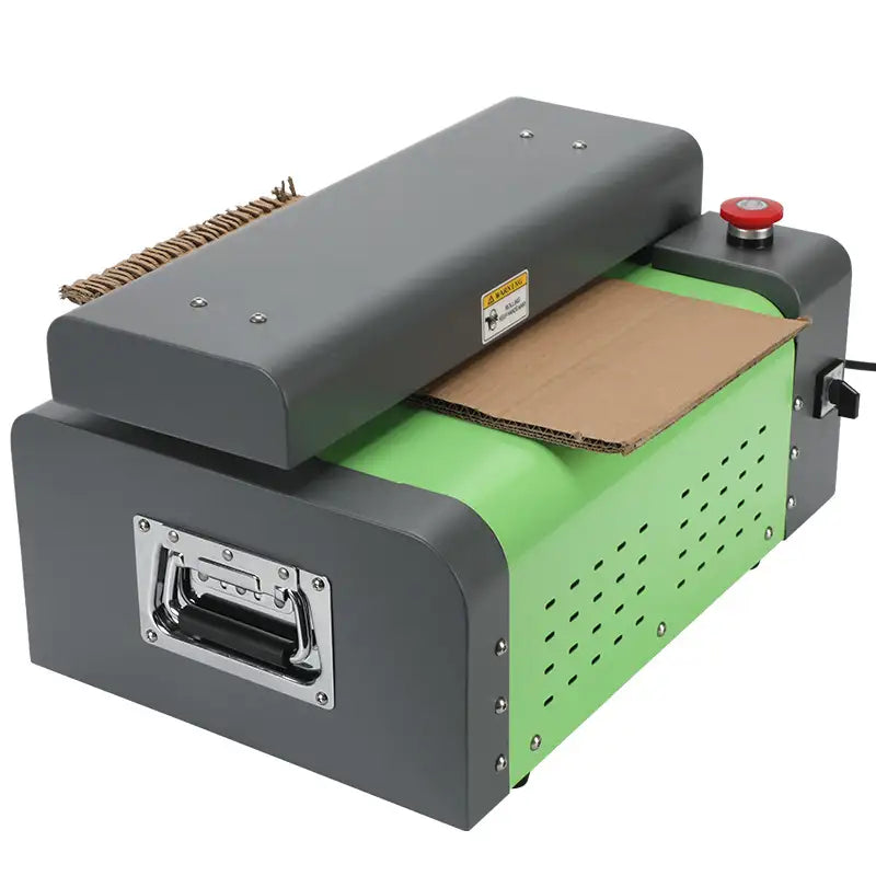 Green and grey cardboard shredder machine with a cardboard sheet on a white background